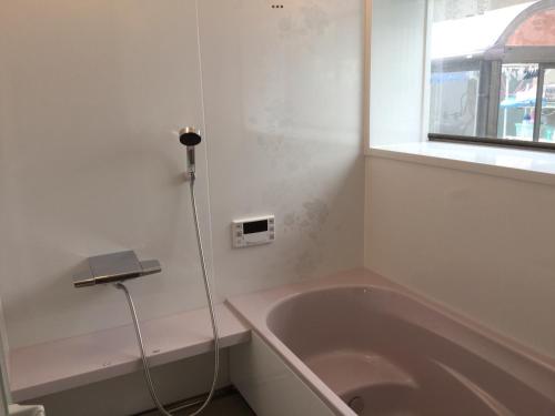a bathroom with a bath tub and a window at Strawberry villa in Ichihara
