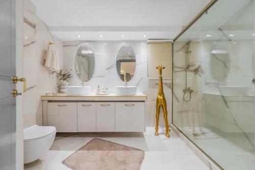 a bathroom with a shower and a giraffe statue in it at Solena Villa in Stavromenos