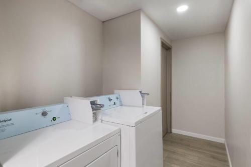 a white laundry room with a washer and dryer at Baymont by Wyndham Mankato in Mankato