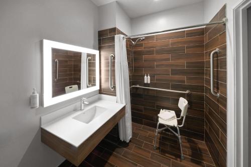 a bathroom with a sink and a mirror at Microtel Inn and Suites Baton Rouge Airport in Baton Rouge