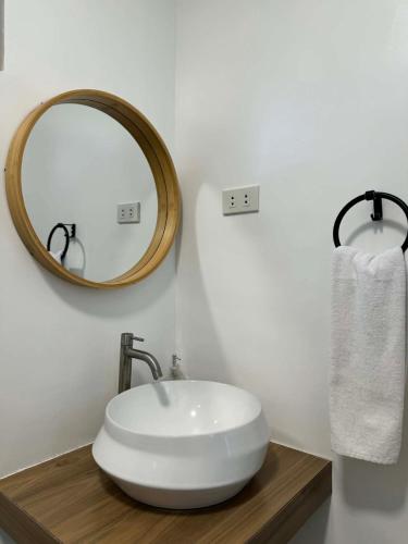 a bathroom with a white sink and a mirror at Paraiso Del Bacnotan in Bacnotan