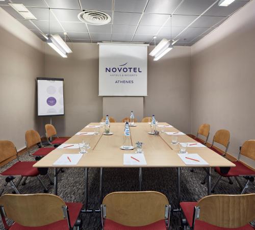 a conference room with a large table and chairs at Novotel Athens in Athens