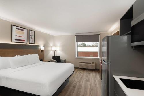 a hotel room with a bed and a refrigerator at Hawthorn Extended Stay by Wyndham Jackson in Jackson