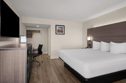 a hotel room with a large bed and a desk at Travelodge by Wyndham Imperial - El Centro in El Centro