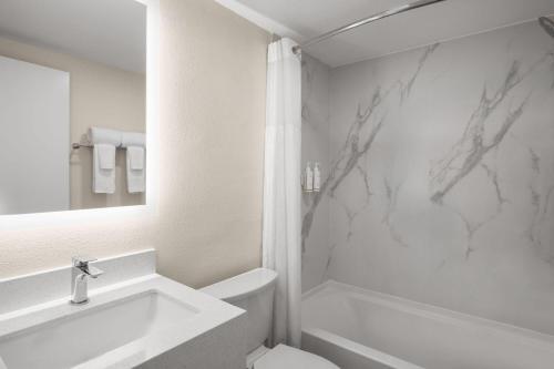 a white bathroom with a sink and a toilet at Travelodge by Wyndham Imperial - El Centro in El Centro