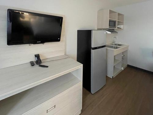 a room with a large flat screen tv on a wall at Suburban Studios Syracuse Carrier Circle in East Syracuse
