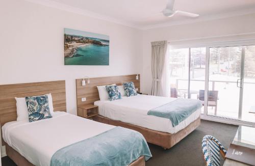 a hotel room with two beds and a window at Yamba Beach Motel in Yamba