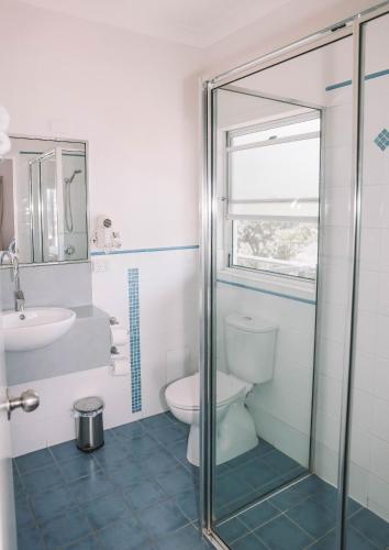 a bathroom with a toilet and a sink at Yamba Beach Motel in Yamba