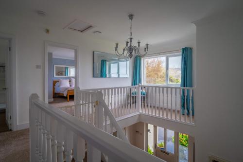 a white staircase in a room with a window at Croft House in Croyde