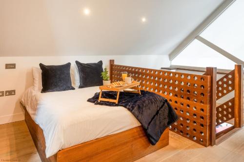 a bedroom with a large bed with a wooden headboard at Croyde Barn in Croyde