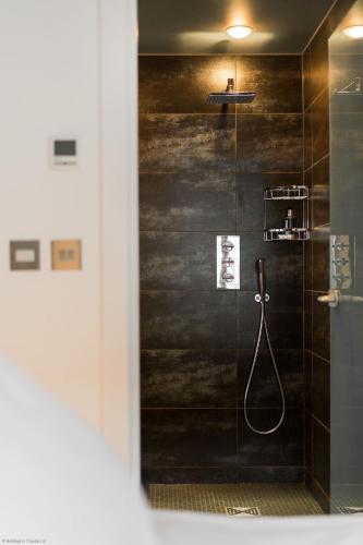 a bathroom with a shower with a black wall at Croyde Barn in Croyde