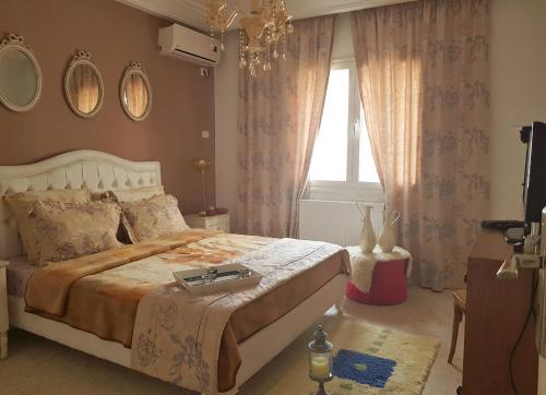 a bedroom with a large bed and a window at Confort house in Nabeul