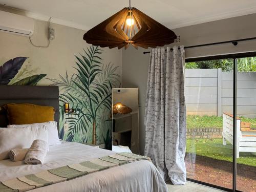 a bedroom with a bed and a large window at The Chalant in Tzaneen
