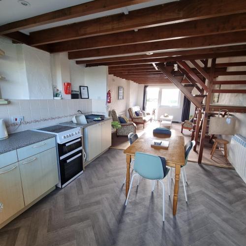 a kitchen with a table and a dining room at Fadrun Cottage in Llangian