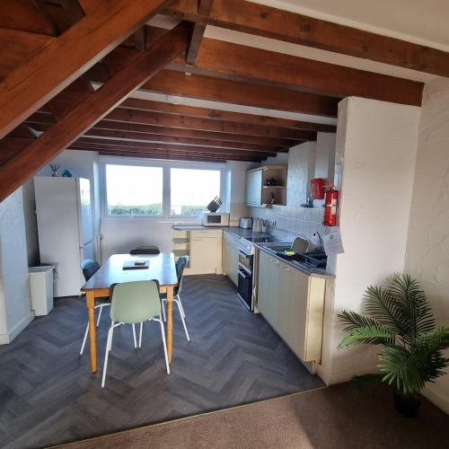 a kitchen with a table and chairs in a room at Fadrun Cottage in Llangian