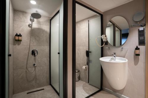 a bathroom with a shower and a sink and a mirror at Utkubey Hotel in Gaziantep