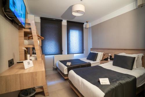 a room with two beds and a tv and a staircase at Utkubey Hotel in Gaziantep