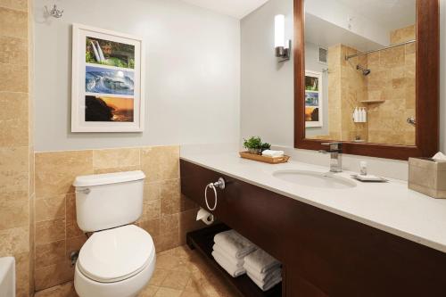 a bathroom with a toilet and a sink at Kauai Beach Resort in Lihue