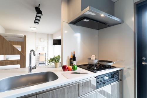a kitchen with a sink and a stove at BON Tokyo Kamata Parkside in Tokyo