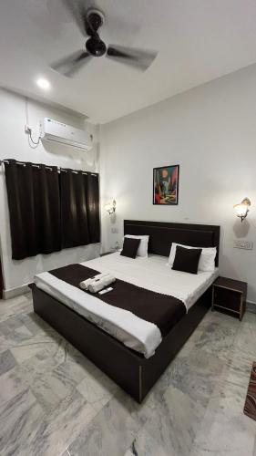 a bedroom with a large bed with a ceiling fan at Pushkar Stay in Varanasi