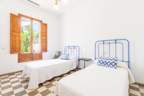 two beds in a room with a checkered floor at Palma Ca'n Alonso in Palma de Mallorca