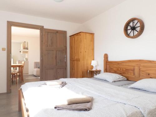 a bedroom with two beds and a clock on the wall at Apartmán Dvojka in Benecko