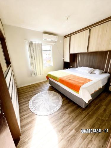 a bedroom with a large bed and a wooden floor at Casa Zibell centro de Pomerode in Pomerode