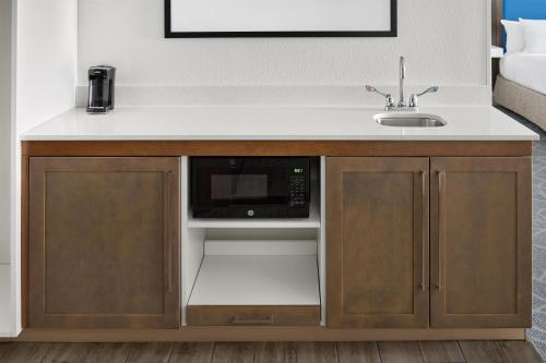 a kitchen counter with a sink and a microwave at Hampton Inn & Suites Syracuse North Airport Area in North Syracuse
