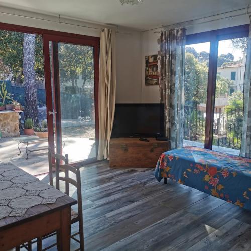a living room with a bed and a tv and sliding glass doors at Casa Nel Verde Vista Mare in Quercianella
