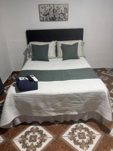 a bedroom with a large bed with a white and gray blanket at Tuncosurfhouse in El Sunzal