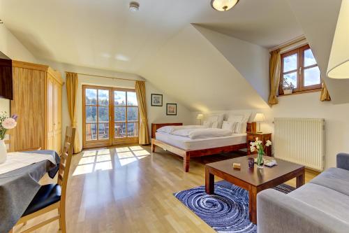 a bedroom with a bed and a couch and a table at Haus Jägerfleck, Ihre Ferienwohnungen am Nationalpark Bayerischer Wald in Spiegelau