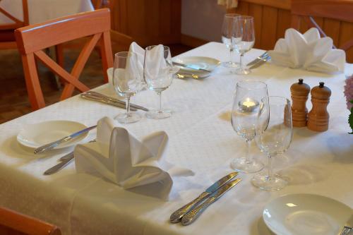a table with a white table cloth with wine glasses at Hotel Alpsu in Disentis