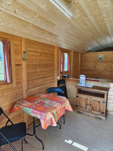 a dining room with a table and chairs in a cabin at Camping La Hêtraie pipowagen in Bullange
