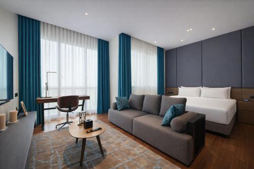 a hotel room with a couch and a bed at Dao By Dorsett Puteri Cove in Johor Bahru