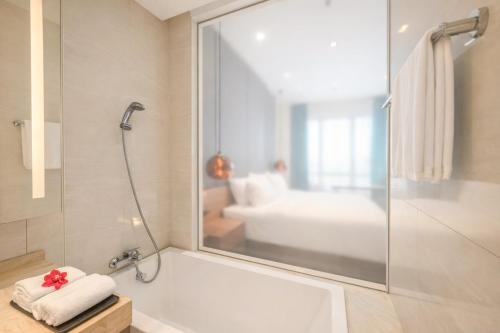 a bathroom with a shower and a bath tub at Dao By Dorsett Puteri Cove in Johor Bahru