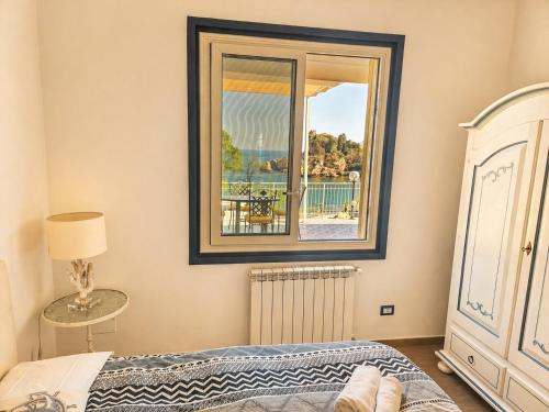 a bedroom with a bed and a window with a view at Taormina Isola Bella Apartment - Taormina Holidays in Taormina