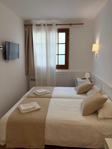 ein Schlafzimmer mit einem großen Bett, auf dem zwei Handtücher liegen in der Unterkunft Hotel Torino in Masnou