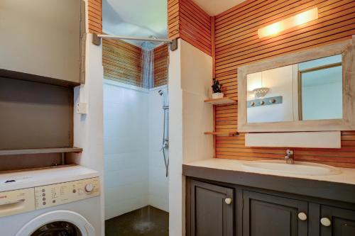 a bathroom with a sink and a washing machine at Marine House Pointe d'Esny in Blue Bay