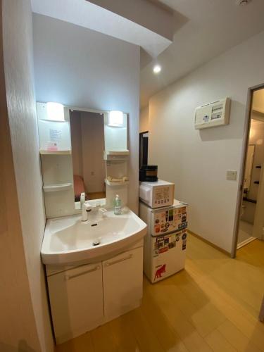 a small kitchen with a sink and a microwave at Hotel MR TOMO ATAMI 102 in Atami
