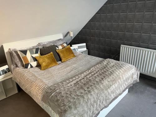 a bedroom with a large bed with yellow and black pillows at BAE SUITE 5 min walk to bae systems in Barrow in Furness