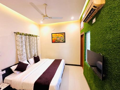 a bedroom with a bed and a green wall at Hotel The Galaxy in Dabok