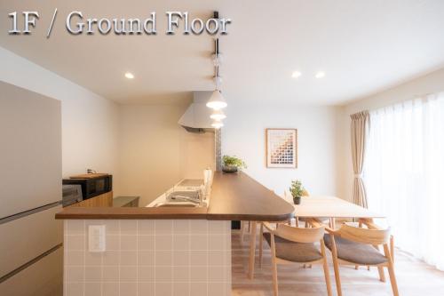 a kitchen with a sink and a table with chairs at Kitasaito Terrace C in Asahikawa