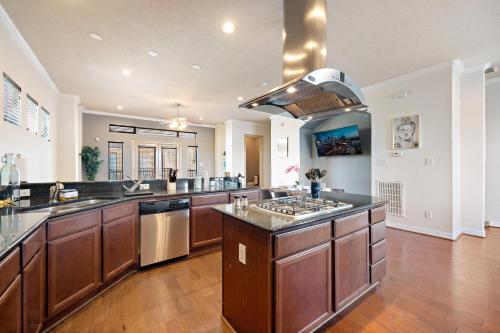 a large kitchen with wooden cabinets and a large island at Near DT, Heights, Washington WiFi Games BBQ in Houston