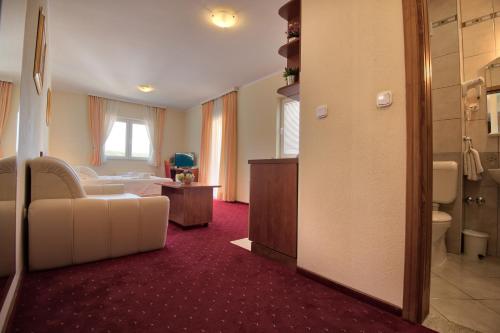 a hotel room with a bed and a bathroom at Hotel AGAVA in Neum