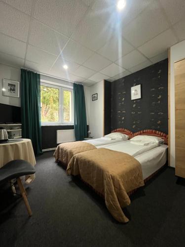 a hotel room with two beds and a window at Amphora Kompleks Wypoczynkowy in Krynica Zdrój