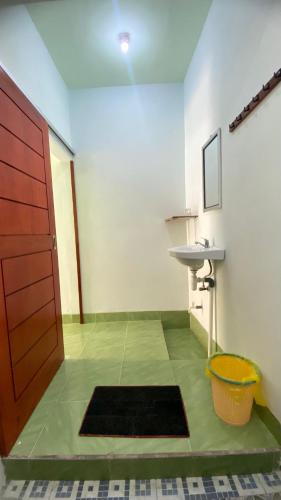 a room with a bathroom with a sink and a door at Mango Lodge in Gili Gede