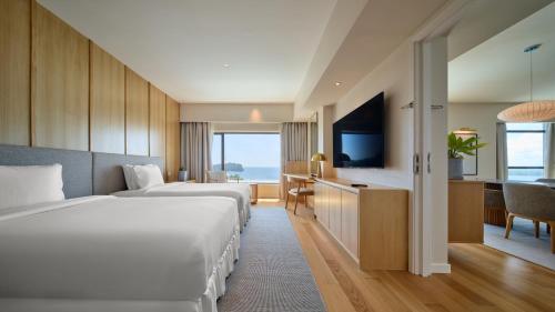 a hotel room with two beds and a television at Ormond Sandakan in Sandakan