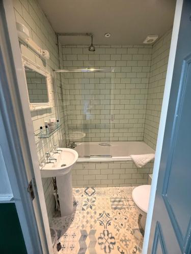 a bathroom with a tub and a sink and a toilet at The Royal Oak Ripon in Ripon