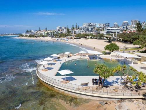an aerial view of a beach with a swimming pool at Riverstone Crescent Residence in Caloundra West