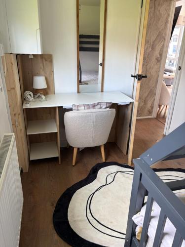 a room with a desk and a chair and a mirror at Edwards cabin in Caeathro